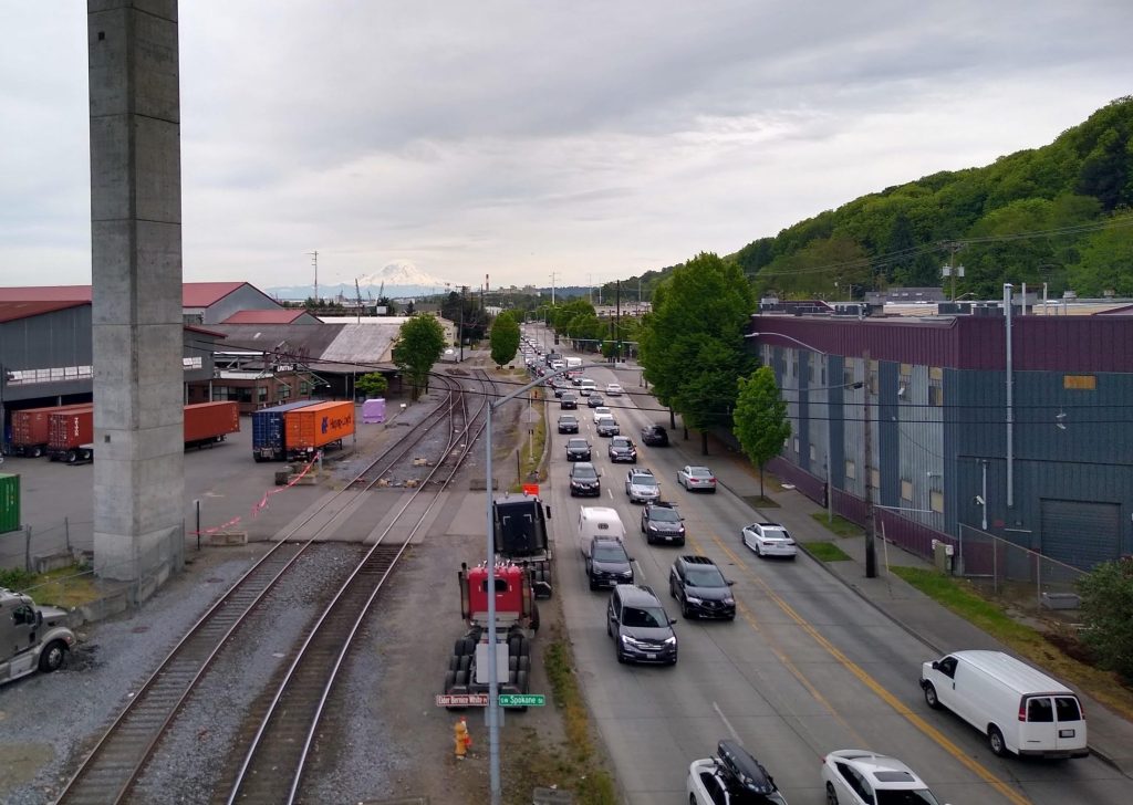 West Marginal Way filled with cars below the West Seattle High Bridge, with Mount Rainier in the distance