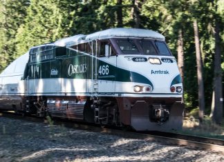 All Aboard Washington Releases New Passenger Rail Vision Map A photo of an Amtrak Cascades locomotive car surrounded by forest.