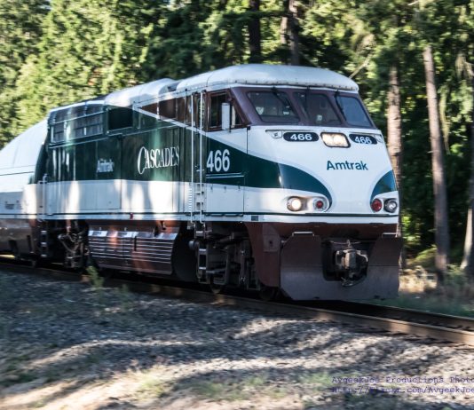 All Aboard Washington Releases New Passenger Rail Vision Map A photo of an Amtrak Cascades locomotive car surrounded by forest.