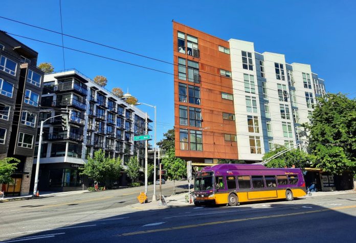 Trolley on 1st and Denny 20210513 A Route 33 trolley bus at the intersection 1st Avenue and Denny Way with low-rise apartment buildings behind.