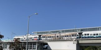 A photo of an elevated Link light rail line over a street.