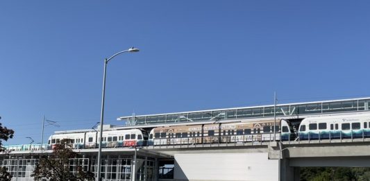 A photo of an elevated Link light rail line over a street.