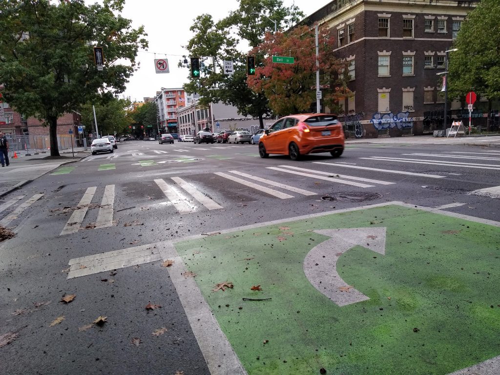 Large green square on the street for bikes, with no bike lane behind.