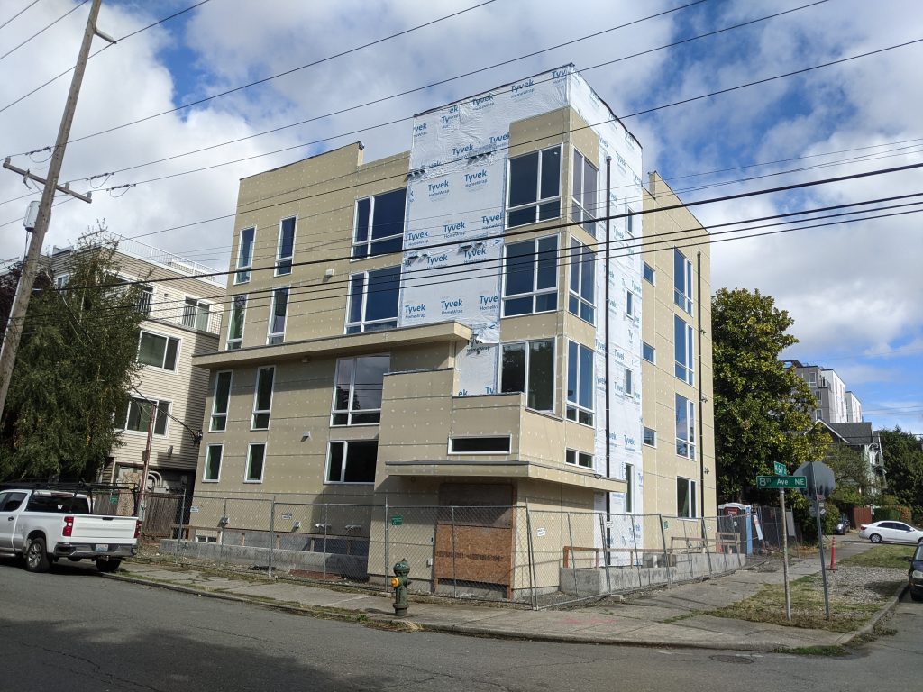 An under construction apartment building at 800 NE 64th St, across from I-5