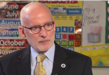 Appeal Denied: Compassion Seattle’s Charter Amendment is Dead Tim Burgess is a bald white man with glasses dressed in a dark suit and yellow tie.