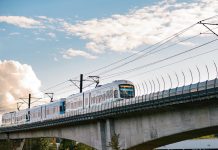 Seattleites Support a New Funding Measure to Expand Light Rail, Poll Finds A view of an elevated light rail track with a train approaching.