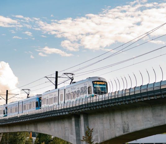 Seattleites Support a New Funding Measure to Expand Light Rail, Poll Finds A view of an elevated light rail track with a train approaching.