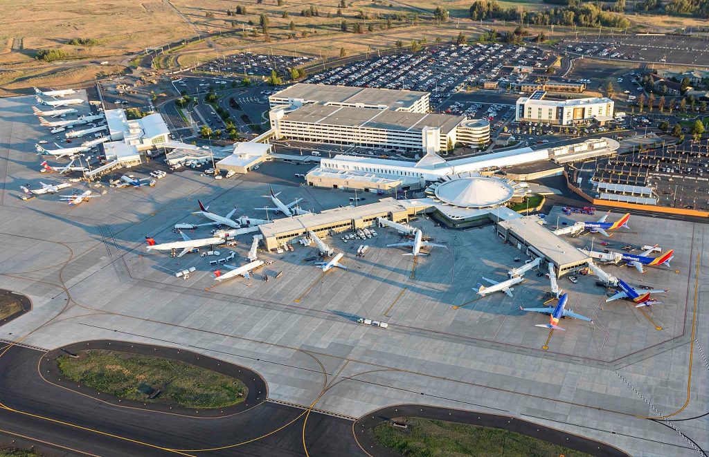 An photo showing an aerial view of the Spokane airport terminal and runway with planes.
