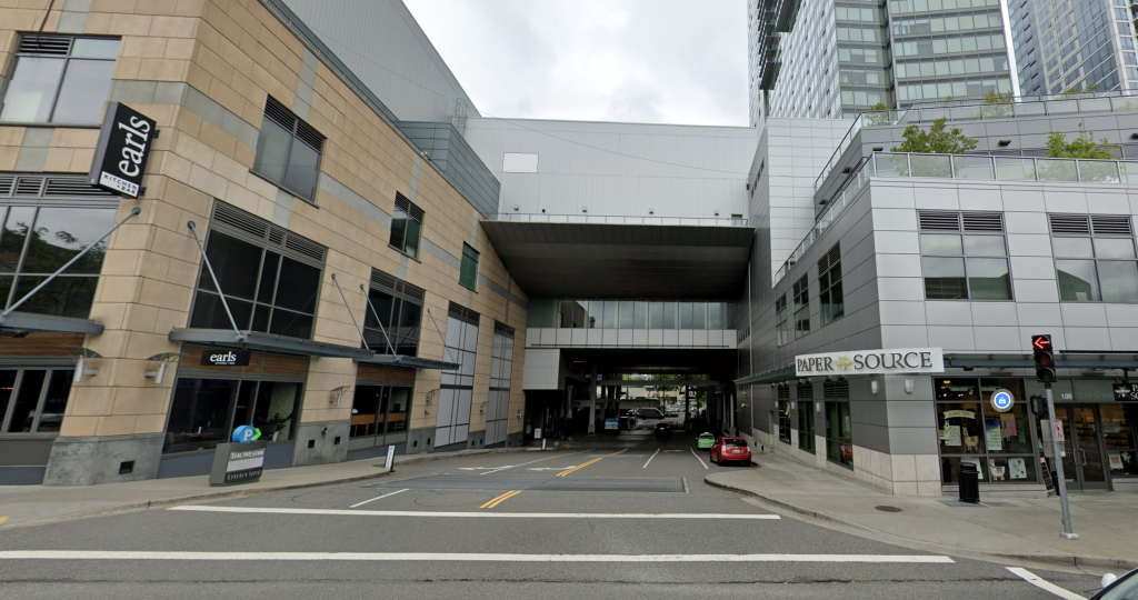 A photo of an intersection between two commercial buildings connected by a skybridge. 
