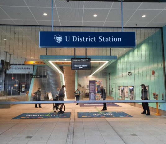 All Aboard The Urbanist’s Fall 2021 Subscriber Drive A bicyclist exists the 43rd Street gate of U District Station.