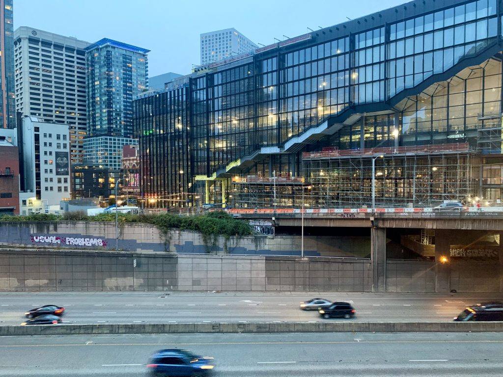 A photo shows the almost complete new Washington State Convention center adjacent to I-5 in Downtown Seattle. 