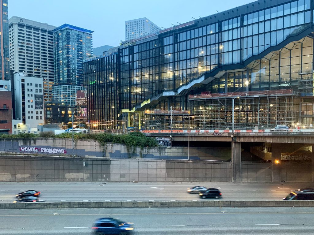 A photo shows the almost complete new Washington State Convention center adjacent to I-5 in Downtown Seattle.