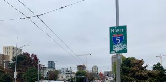 A photo shows a sidewalk next to a roadway with cars. A sign says North Interstate 5.