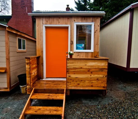 Advocates Debate Tiny House Villages’ Role in Reducing Homelessness A photo of a tiny house with an orange door.