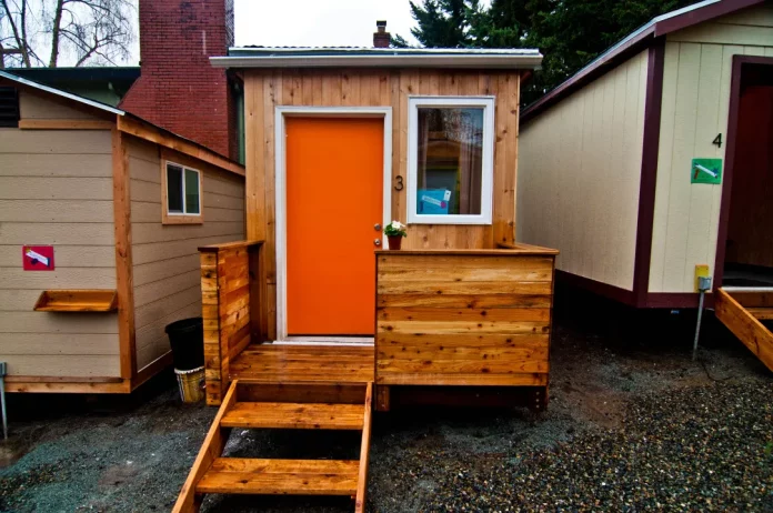 A photo of a tiny house with an orange door.