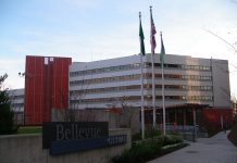 Unprecedented Special Interest Money Floods Bellevue Election A photo of a modern grey and red building with three flags in front of it.