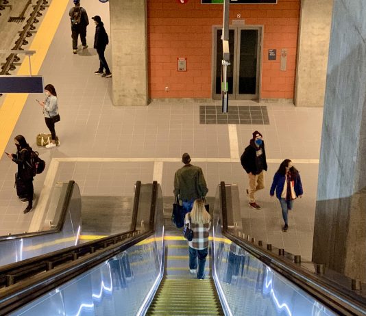 Northgate Link Light Rail Expansion: How We Arrived A photo of an illuminated escalator leading down to a light rail platform.