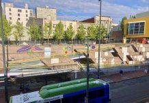 Speedier Bus Service in 2022 and New Public Art, Among Pierce Transit Updates A photo shows a bus in front a public art water feature with brightly colored images painted on cement.