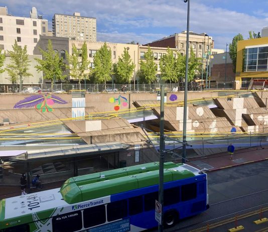 Speedier Bus Service in 2022 and New Public Art, Among Pierce Transit Updates A photo shows a bus in front a public art water feature with brightly colored images painted on cement.