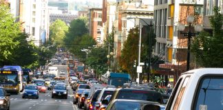 A photo of backed up car traffic on the right side of the road. Cars are approaching on the left side of the road.