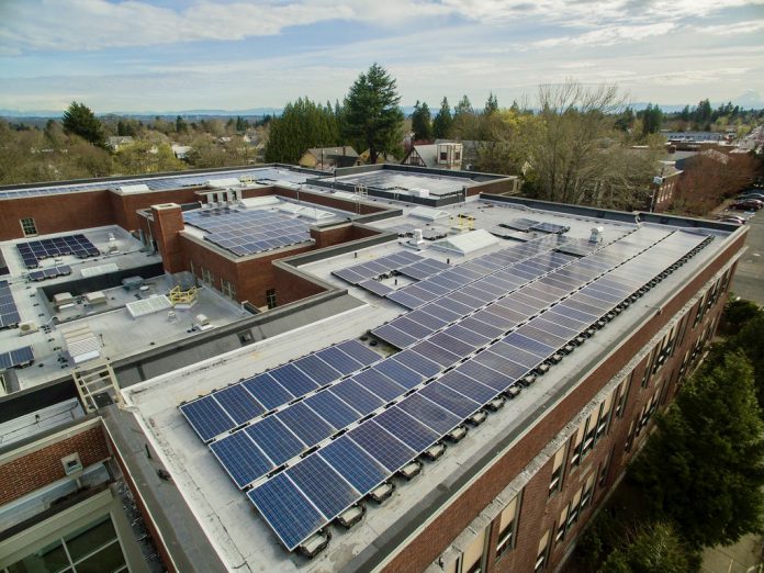 A photo of a solar array on the rooftop of a school building.