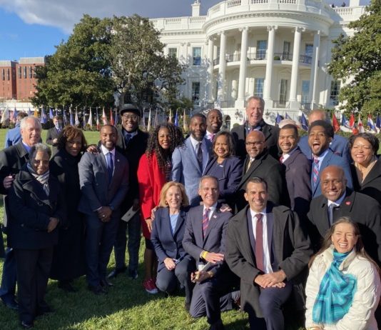 A Closer Look at Biden’s Historic Infrastructure Bill A group of people in business attire pose in from the White House.