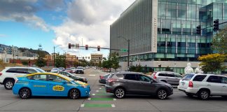 A photo showing cars blocking a marked intersection for pedestrians.