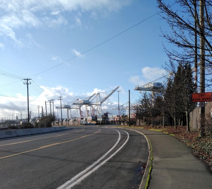 A gutter bike lane with the Port's tower cranes in the background.