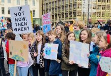 Former AIA Seattle Executive Director on Experiencing COP26 A photo of children holding signs that demand action to fight climate change.