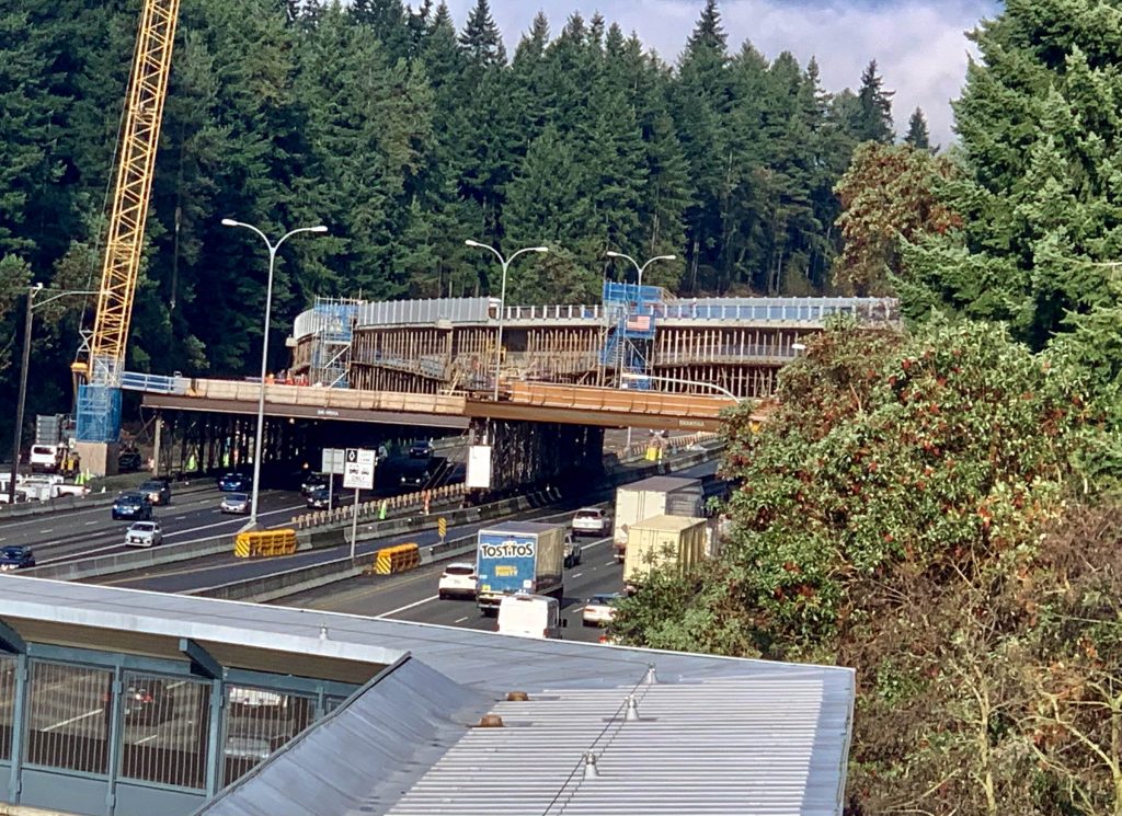 A photo of light rail tracks in construction over an interstate.