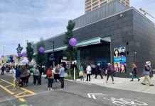 Pedestrian Streets, Protected Bike Lanes, and Bus Lanes Are Popular, NPI Poll Shows A photo showing people gathered on a street with a bike lane in front the U District light rail station.