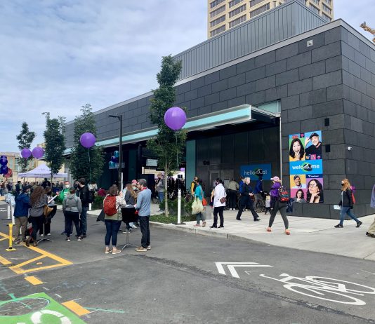 Pedestrian Streets, Protected Bike Lanes, and Bus Lanes Are Popular, NPI Poll Shows A photo showing people gathered on a street with a bike lane in front the U District light rail station.