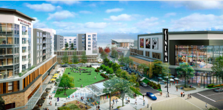 A rendering of residential and commercial buildings surrounding a town square.