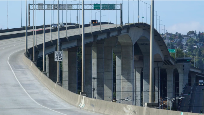 A photo of a high bridge made of a concrete with a roadway.