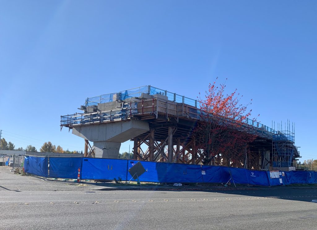 A photo a concrete pillar where light rail tracks under construction end.