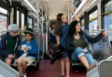 Seattle Expands Free Transit Passes to All Middle Schoolers A photo of a mother with three middle school aged children riding a King County metro bus.