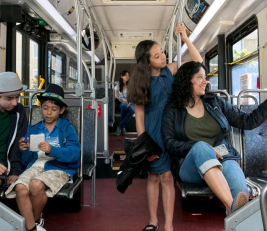 Seattle Expands Free Transit Passes to All Middle Schoolers A photo of a mother with three middle school aged children riding a King County metro bus.