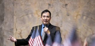 Op-Ed: State Secretary Hobbs Is Wrong to Oppose Ranked Choice Voting Steve Hobbs on the senate floor with American flags in the foreground.