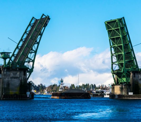 Ballard Bridge Study Builds on Garbage Traffic Forecasts in Interbay Ballard Bridge in a up position to allow a gravel filled barge to go by.