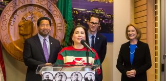 Juarez speaks at a podium with a hockey jersey with the City Seal in the background.