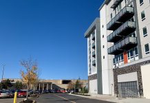 Alderwood Mall Mixes Big Box Stores with Apartment Homes A photo of an apartment next to a parking to with cars and an indoor mall.
