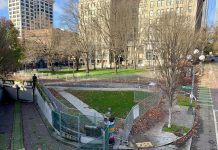 Controversial City Hall Park Land Swap Moves Ahead A photo of a green space surrounded by chain link fencing near tall historic buildings