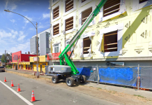 Housing Notes: Seattle’s $143 Million Haul, Townhome Slowdown, More Housing For People Exiting Homelessness A photo of a green crane in front of an apartment building under construction.