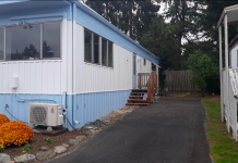 Mobile Home Park Protections to Preserve Up to 11 Acres for Affordable Housing in Bitter Lake A photo of a light blue and white mobile home with a driveway.