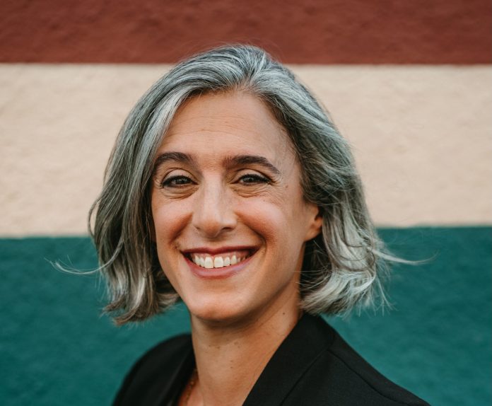 A photo a woman with grey hair wearing a black blazer.
