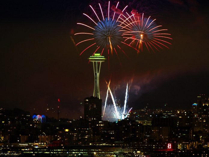 A photo of fireworks at an illuminated space needle