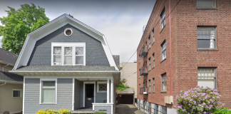 A photo of a single family dwelling and an apartment building separated by an alley.