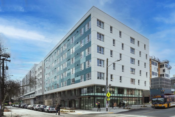 A photo of a white apartment building in an urban area.