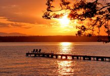 Support Sunsetting Houghton and East Bellevue Community Councils A view of a sunset over a lake with a pier in it.
