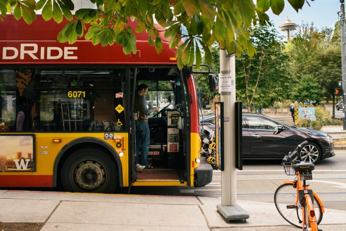 A photo of a Rapid Ride bus at stop with a bike parked in front of it.